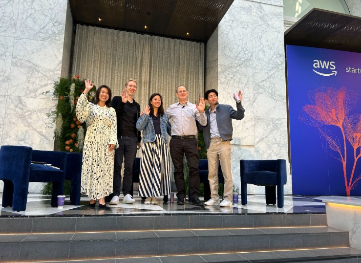The AI Visionaries Forum speakers waving on the AWS Startups stage